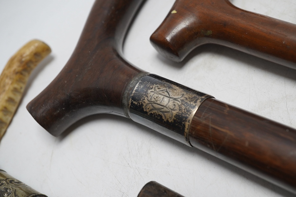 Four mixed silver mounted walking sticks, a riding crop and a baton, longest 88cm. (6). Condition - fair considering use and age